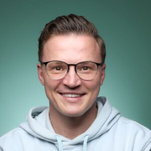 Lächelnder Mann mit Brille und Kapuzenpullover